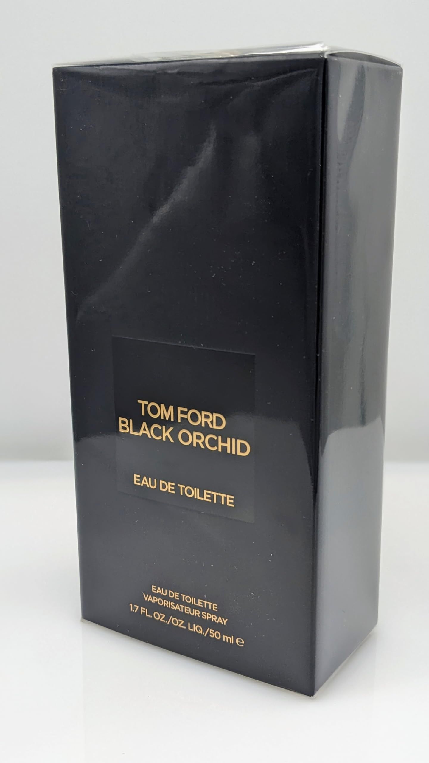 Zwarte verpakking met opschrift: TOM FORD BLACK ORCHID EAU DE TOILETTE. 1.7 FL. OZ./OZ. LIQ./50 ml.