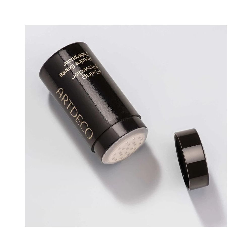 Flacon noir ouvert avec couvercle. Visible: ouverture perforée. Inscription: ARTDECO, Fixing Powder, Poudre fixante, Fixierpuder.