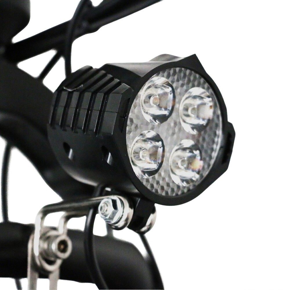 Close-up van een koplamp met vier LED-lampjes. De koplamp is zwart en heeft een gestructureerde behuizing.