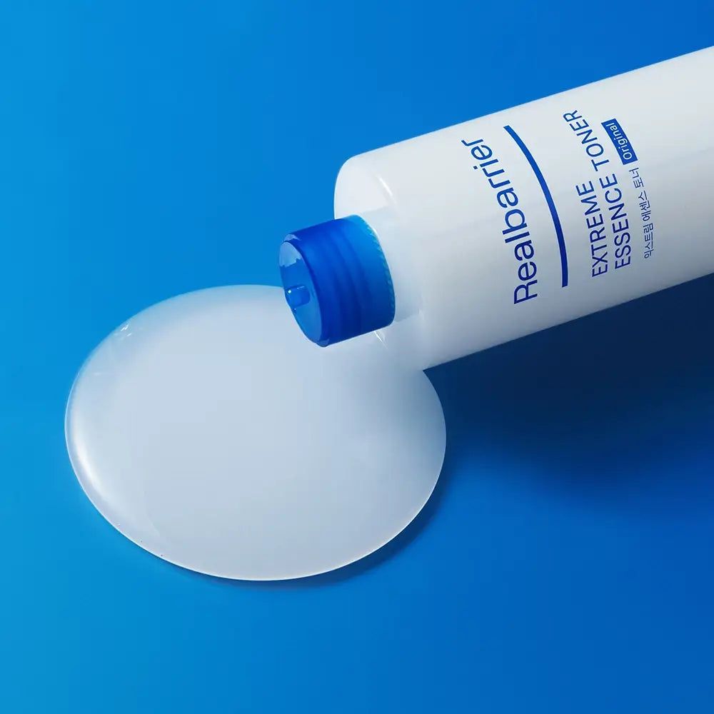 Flacon blanc avec bouchon bleu, liquide versé. Nom du produit et texte visibles.