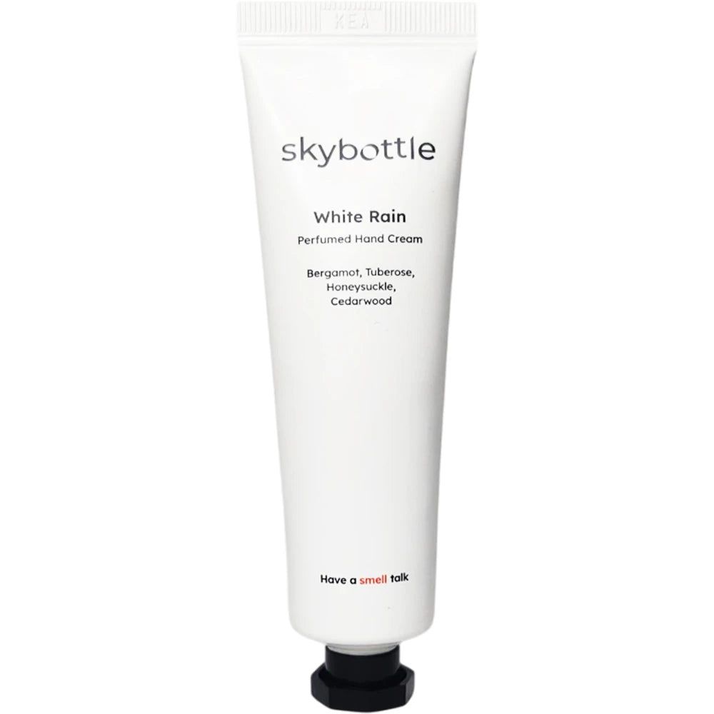 Tube blanc avec bouchon noir. Inscription: skybottle, White Rain, crème pour les mains. Ingrédients: bergamote, tubéreuse, chèvrefeuille, bois de cèdre.