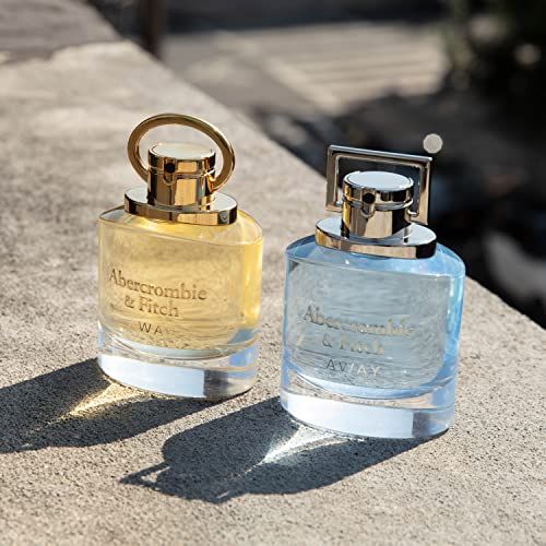 Deux flacons d'Eau de Toilette. Un jaune, un bleu. Inscription : Abercrombie & Fitch AWAY. Posés sur un mur en pierre.