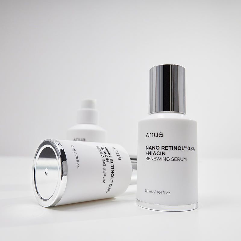 Drie witte flessen met zilveren doppen. Opschrift: Anua, Nano Retinol 0,3% + Niacin, Renewing Serum. 30 ml / 1.01 fl. oz.
