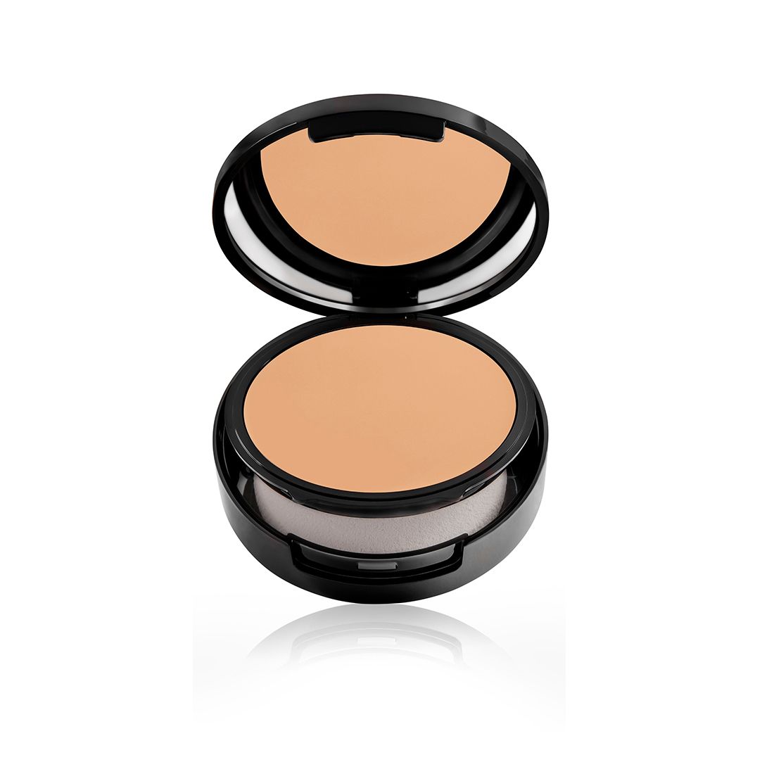 Compacte foundation in een open zwarte verpakking. Met spiegel en sponsapplicator. Zicht op het make-up oppervlak.
