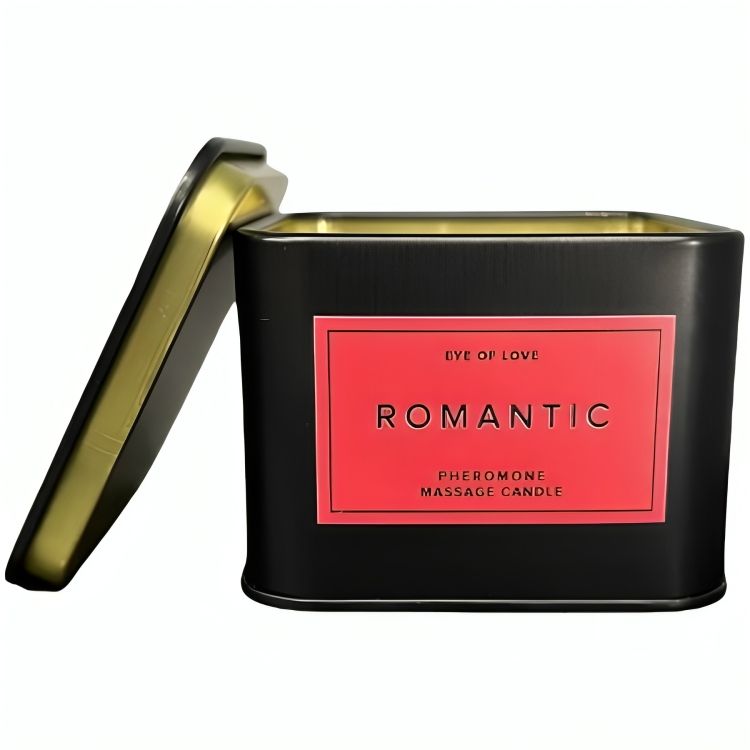 Zwarte metalen blik met rood etiket. Deksel is open en toont een gouden rand. Tekst: Eye Of Love, Romantic, Pheromone Massage Candle.