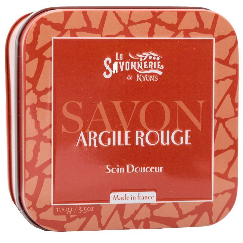 Boîte métallique avec savon à l'argile rouge. Inscription : La Savonnerie de Nyons, Savon Argile Rouge, Soin Douceur. Fabriqué en France.
