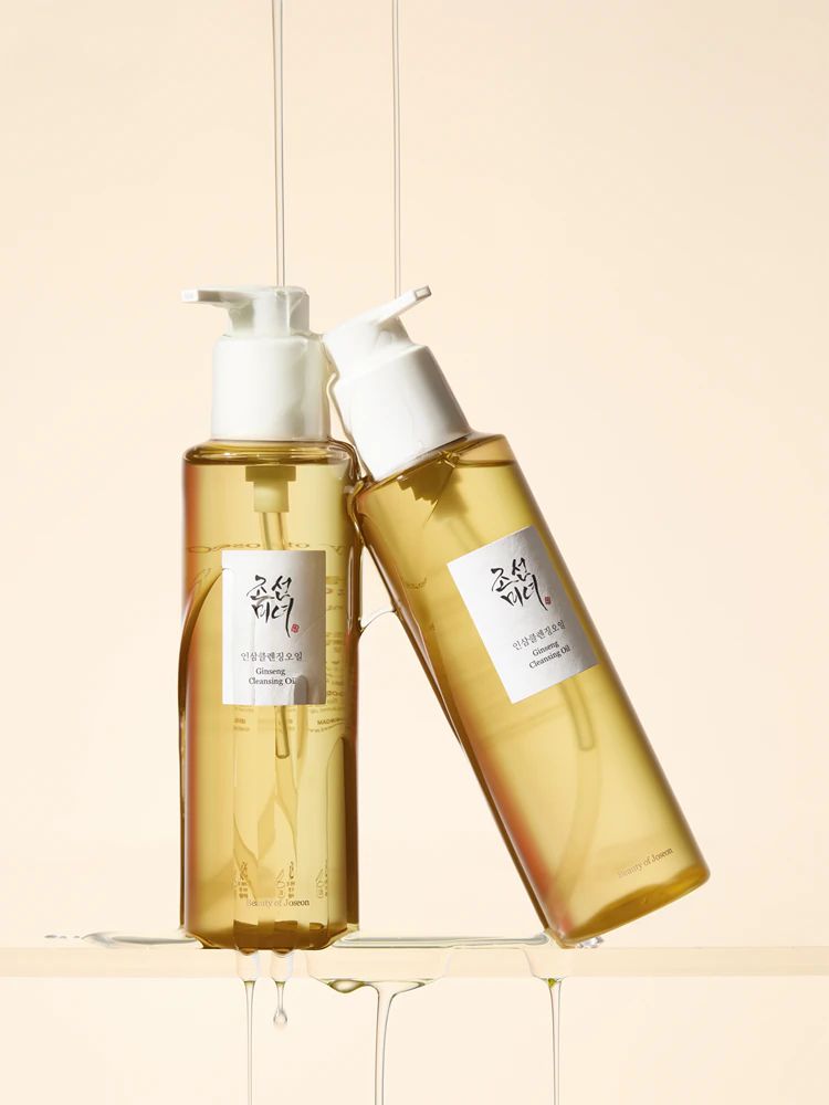 Twee flessen Beauty of Joseon Revive Serum, de ene rechtopstaand, de andere liggend, met serumdruppels.