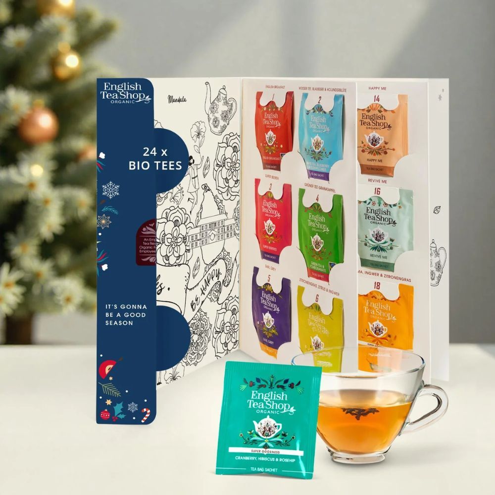 Open adventskalenderdoos met 24 theezakjes. English Tea Shop logo. Een kopje thee ernaast. Tekst "24 x BIO TEES".