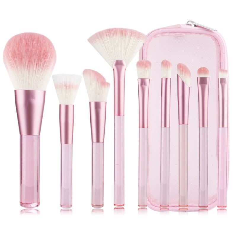 Ensemble de pinceaux de maquillage roses avec étui. Pinceaux avec manches transparents et poils roses. Sur fond blanc.