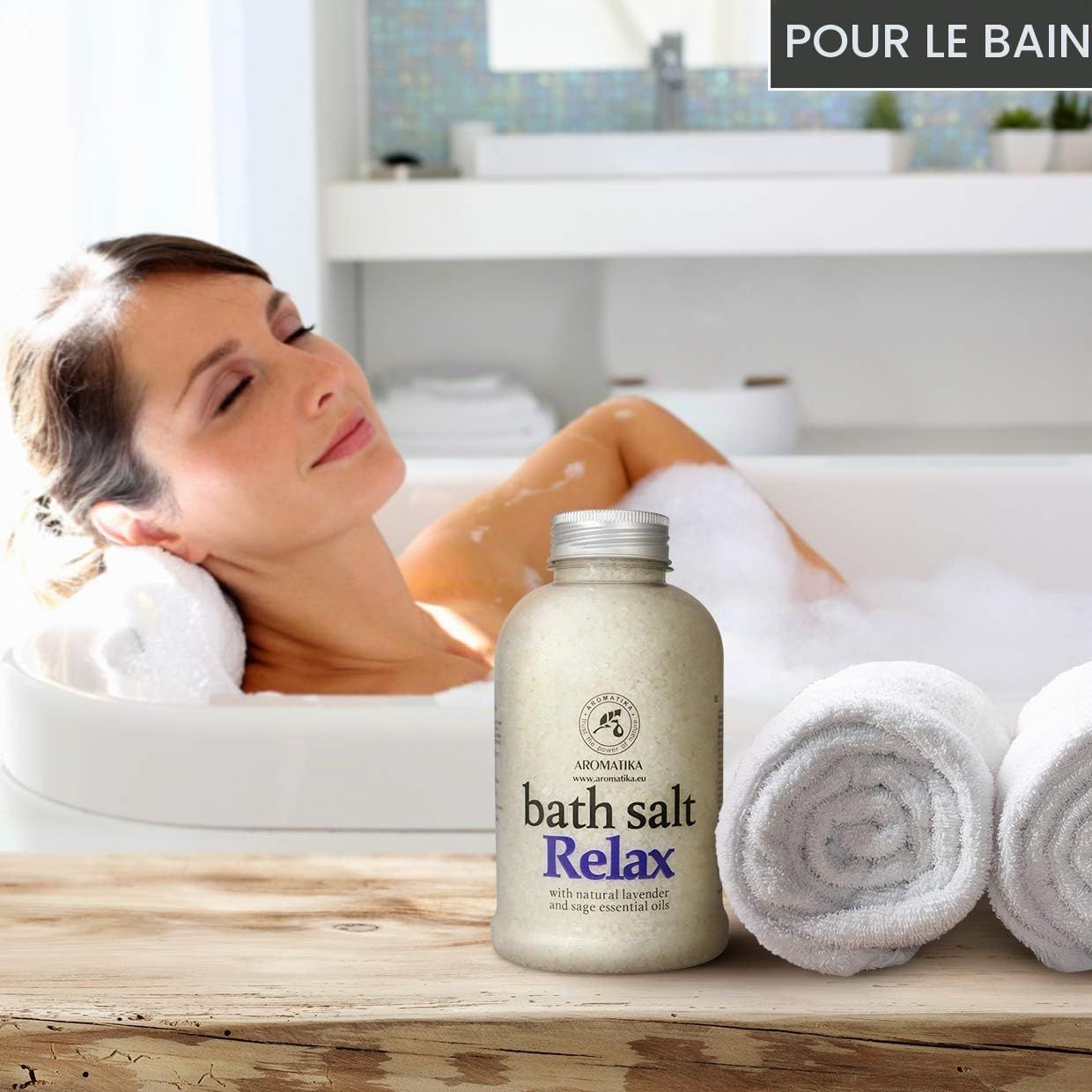 Bouteille de sel de bain 'Relax' à la lavande et à l'huile de sauge. Une femme se détend dans une baignoire.