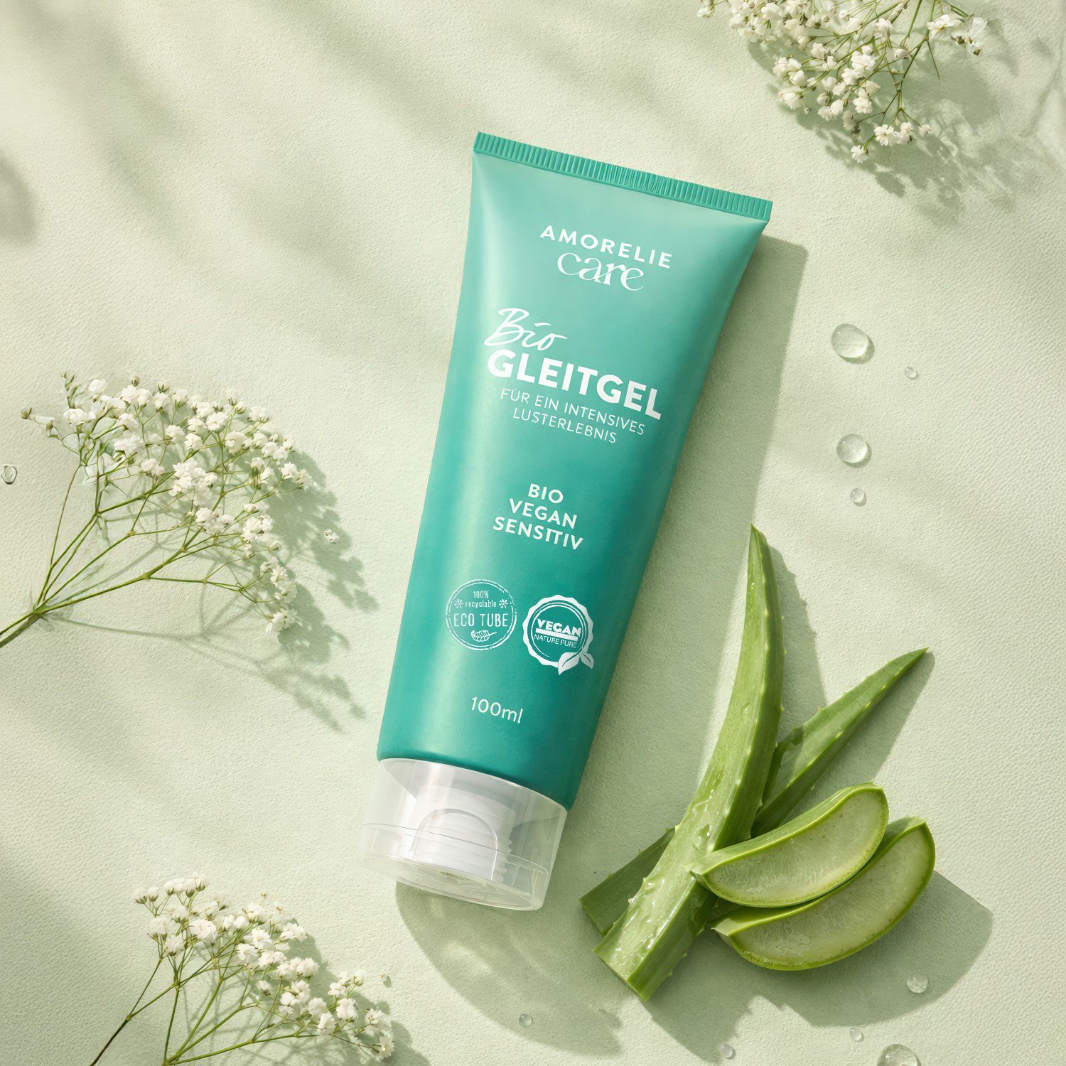 Tube vert avec inscription AMORELIE Care, Bio Gleitgel, à côté d'aloe vera et de fleurs. Sceau végétalien.