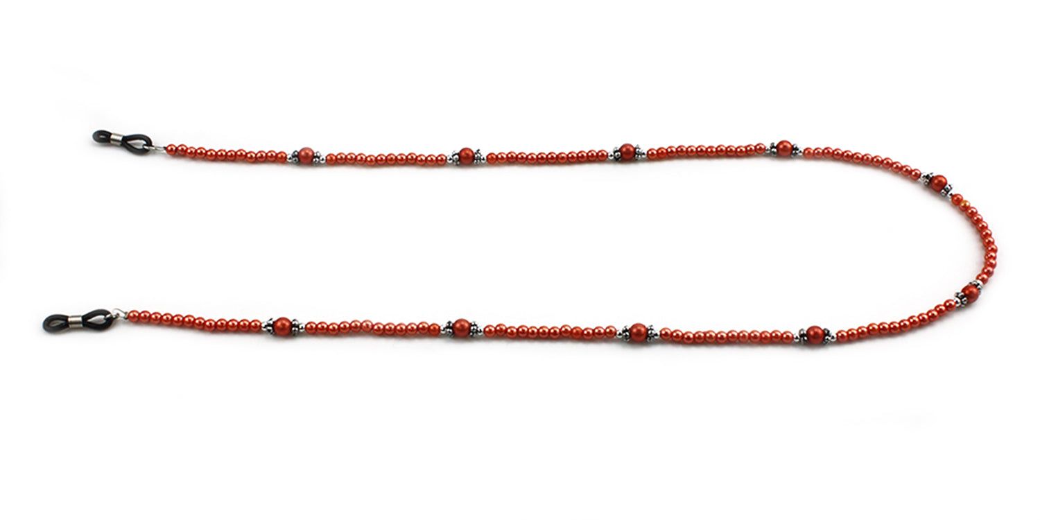 Cordon à lunettes avec perles rouges et éléments argentés. Attaches de lunettes noires aux extrémités. Sur fond blanc.