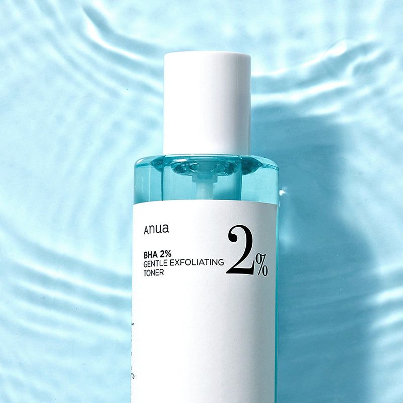 Close-up van de toner. Blauwe vloeistof in een witte fles. Opschrift: Anua BHA 2% Gentle Exfoliating Toner.