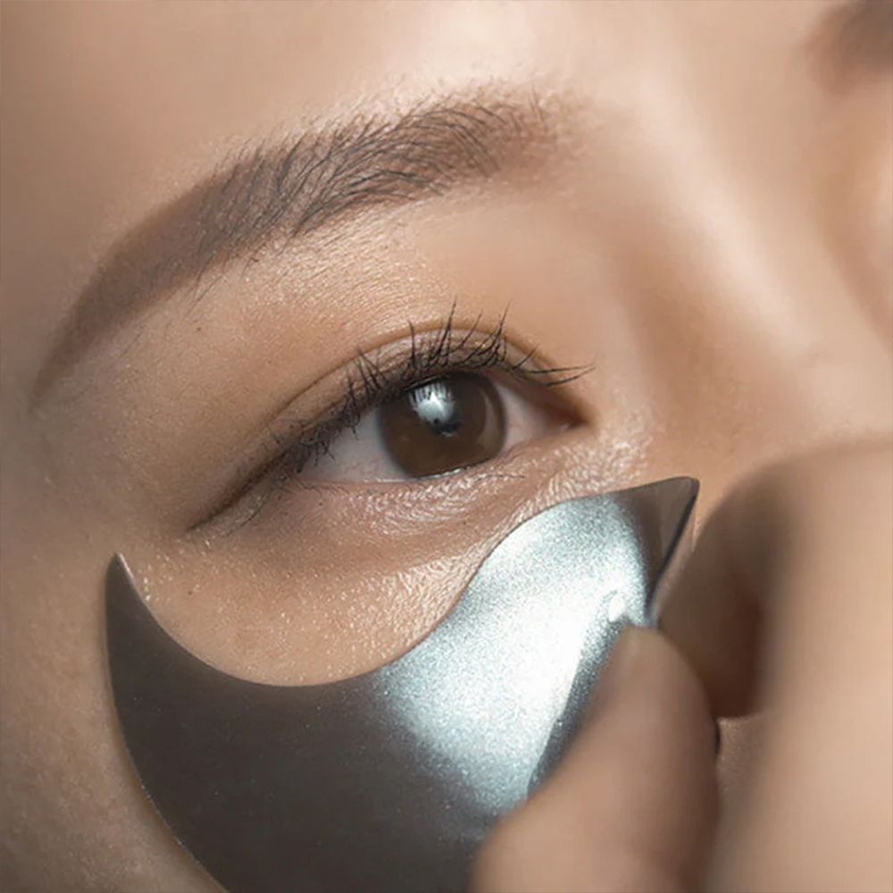 Une personne applique un patch oculaire noir sous l'œil. Gros plan.
