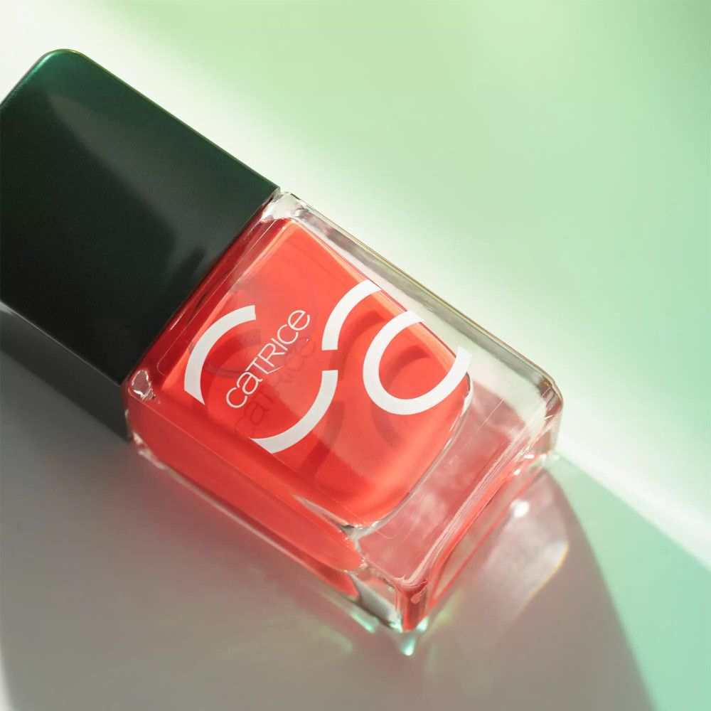 Flacon de vernis à ongles avec vernis rouge. Catrice est écrit sur le flacon.