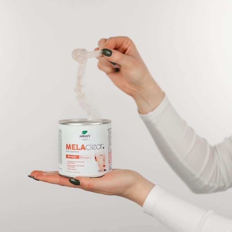 Hand giet poeder van lepel in MELAclear+ blik. Product voor egale huidtint.