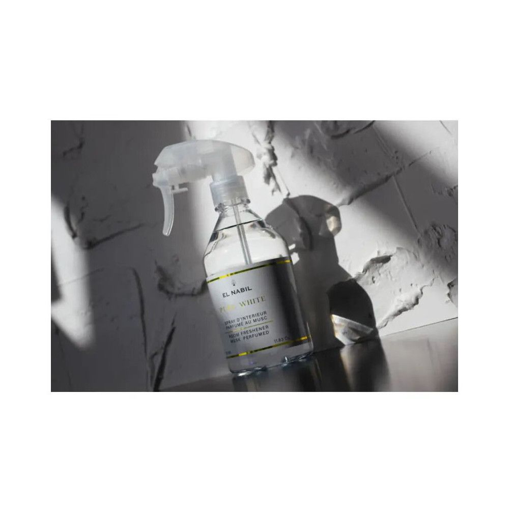 Flacon pulvérisateur transparent avec étiquette blanche. Inscription : El Nabil, Pure White. Tête de pulvérisation en plastique transparent.