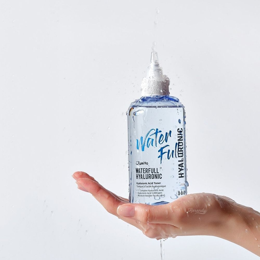 Hand houdt een fles toner vast, water spettert. Opschrift Water Full Hyaluronic. Merk JUMISO.