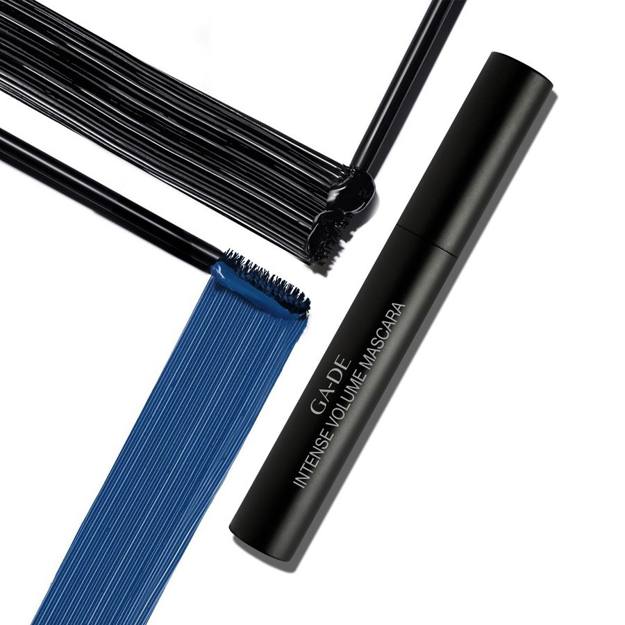 Tube de mascara noir avec brosse et trace de couleur. Inscription: GA-DE Intense Volume Mascara. Couleurs bleue et noire.