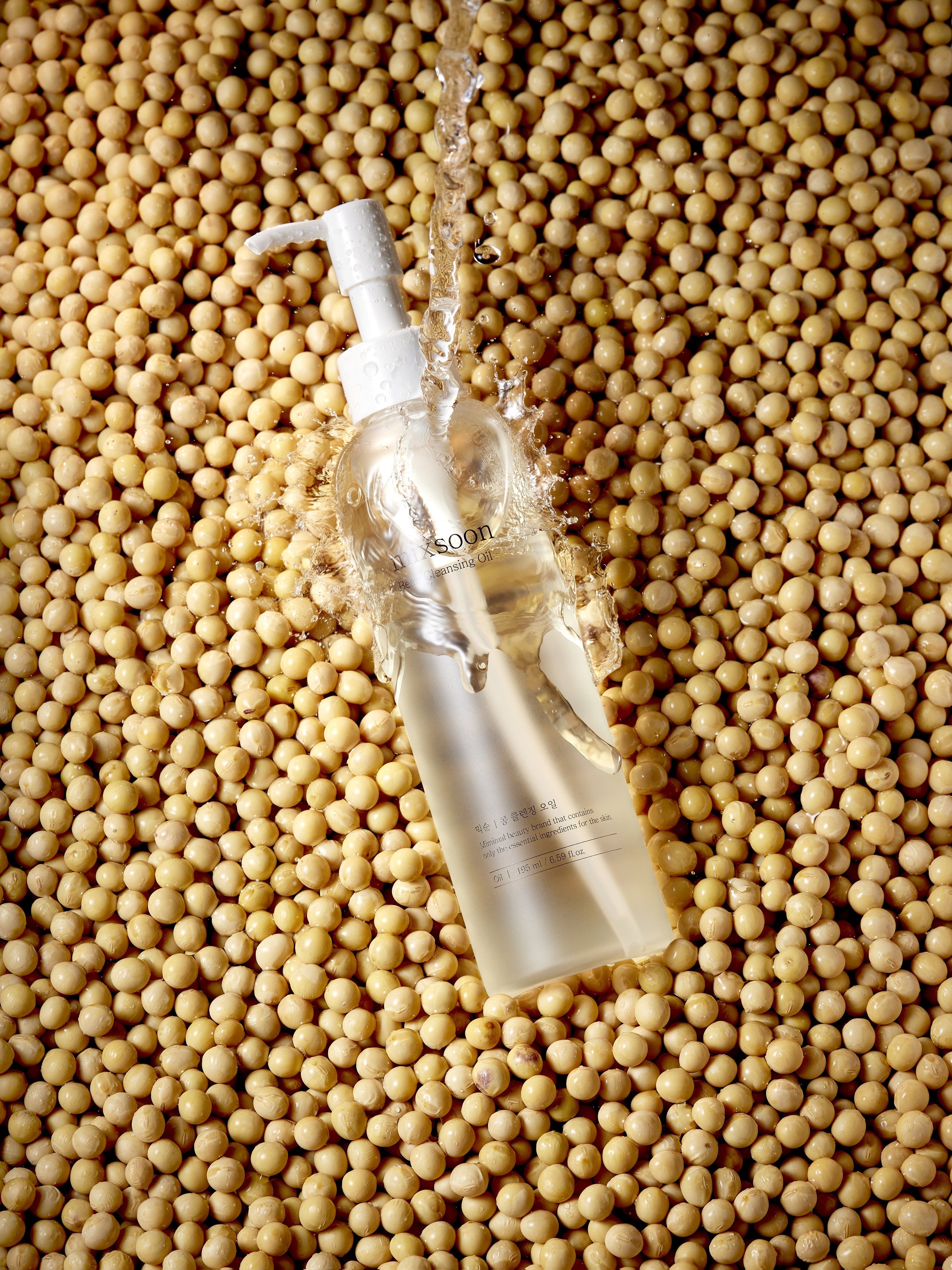 mixsoon Bean Cleansing Oil fles te midden van sojabonen, overgoten met water.