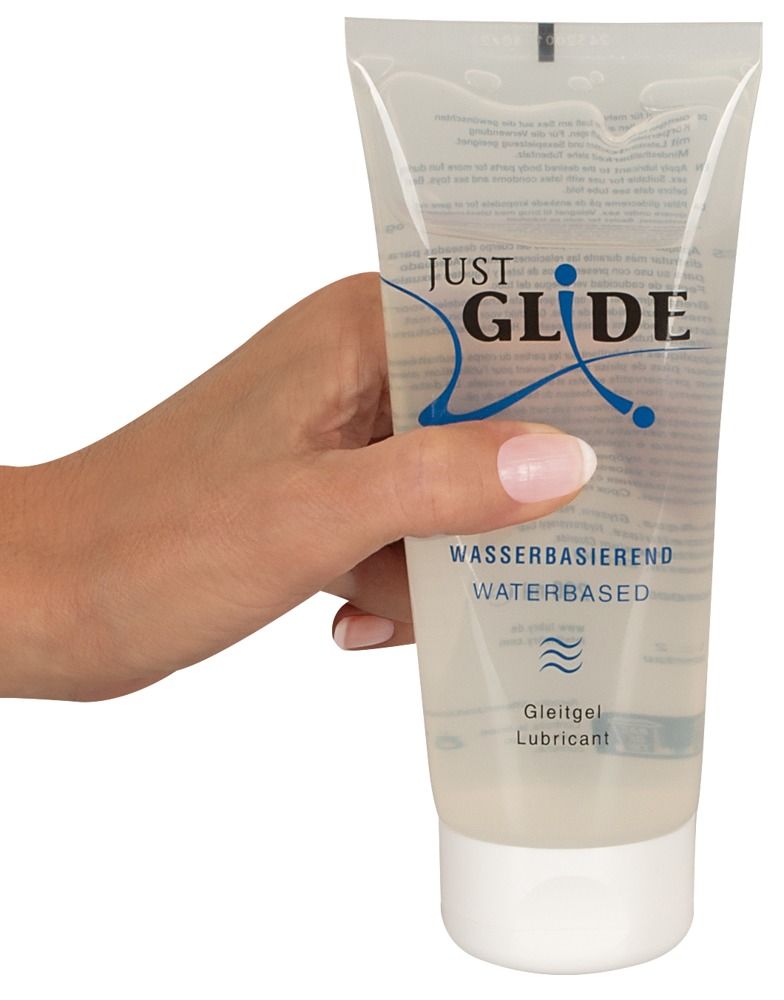 Tube de gel lubrifiant tenu par une main. Inscription: Just Glide, à base d'eau.