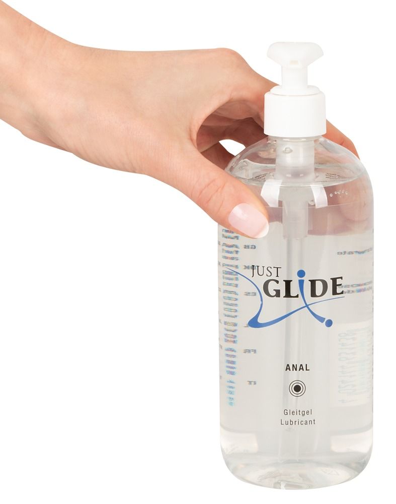 Transparante fles met doseerpomp. Opschrift: JUST GLIDE ANAL. Glijmiddel. Hand houdt de fles vast.