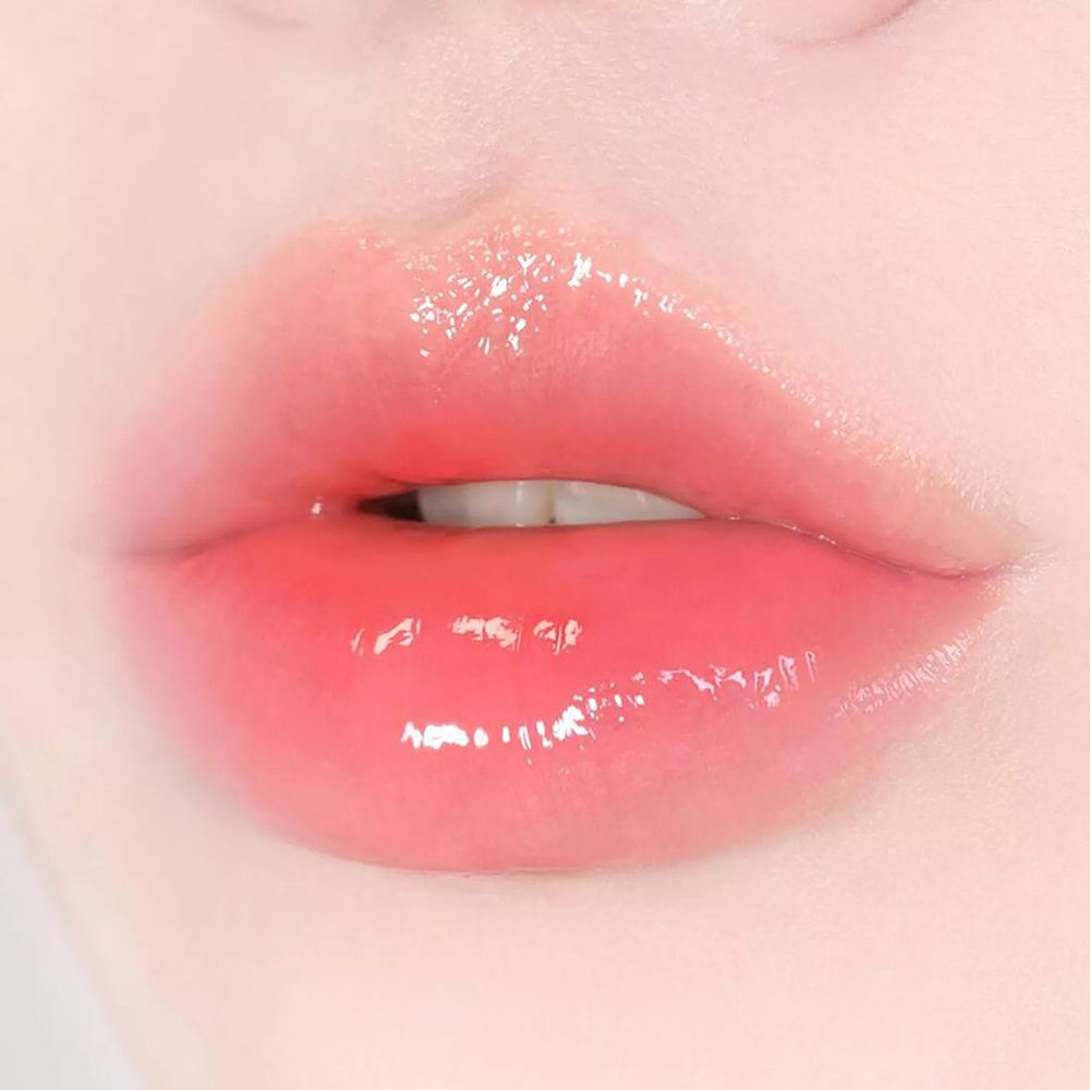 Close-up van glanzende, roze lippen. De lippen zijn lichtjes geopend.