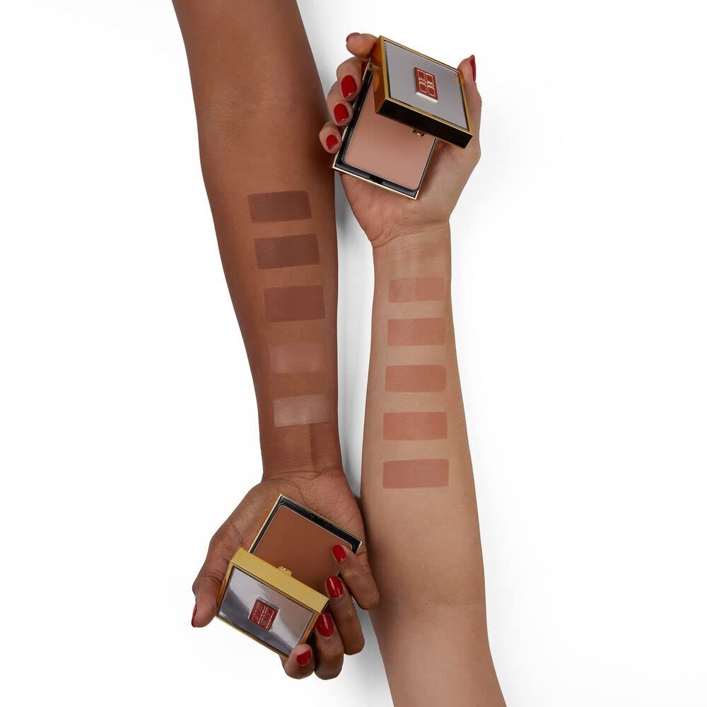 Deux mains tenant des boîtiers compacts dorés. Couleurs de maquillage appliquées sur les avant-bras.