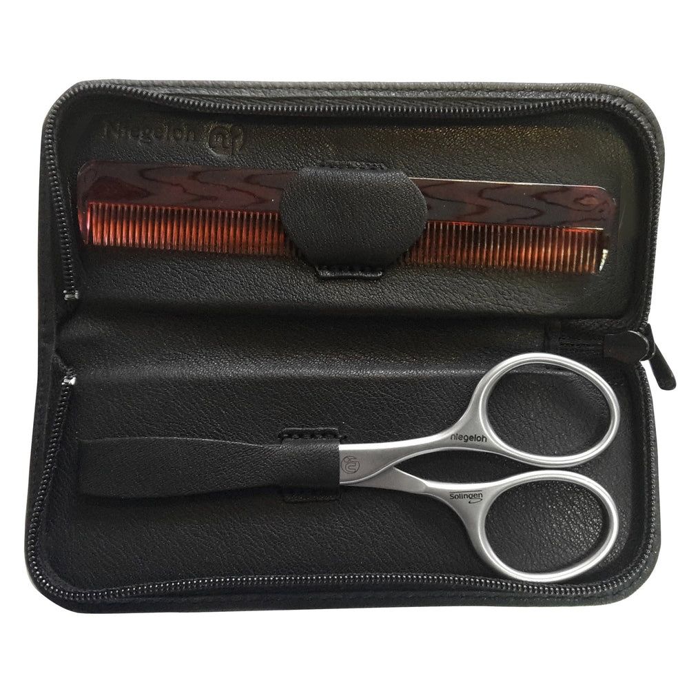 Zwarte etui met kam en baardschaar. Kam bruin, schaar zilverkleurig. Niegeloh-logo zichtbaar.