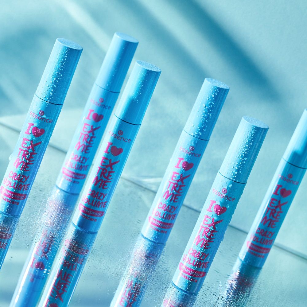 Plusieurs tubes de mascara turquoise, légèrement mouillés. Texte rose "I Love Extreme Crazy Volume Waterproof Mascara".