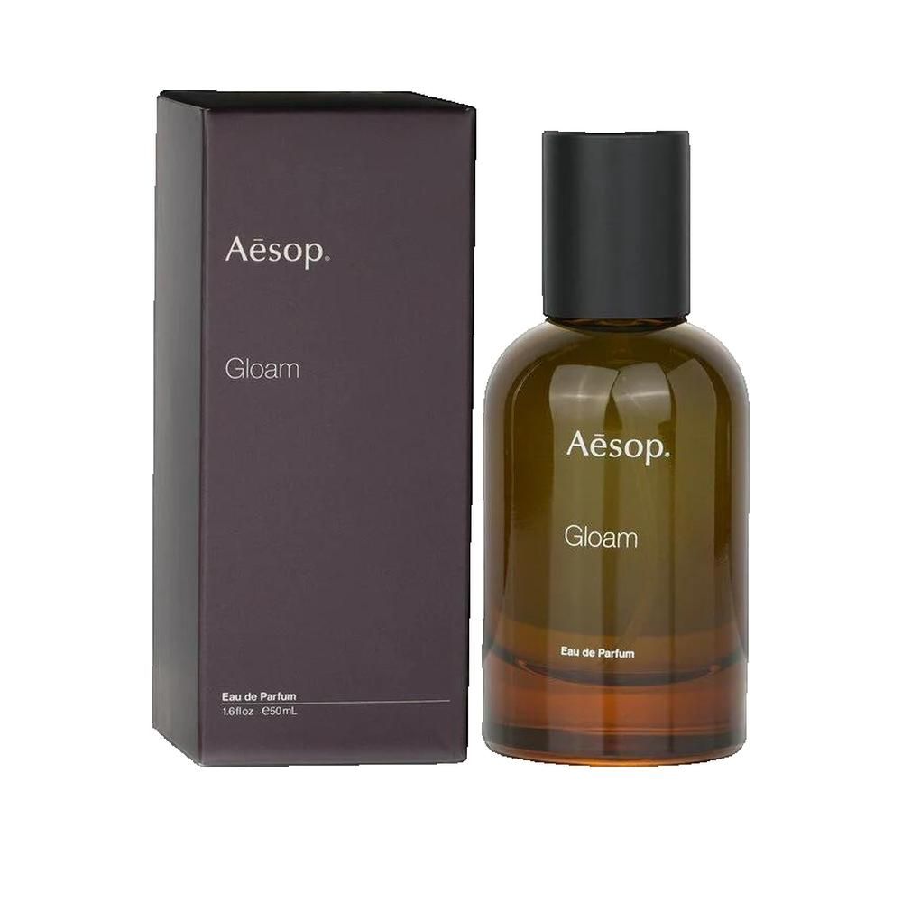 Flacon en verre brun avec bouchon noir et emballage. Logo Clarins et inscription Gloam.