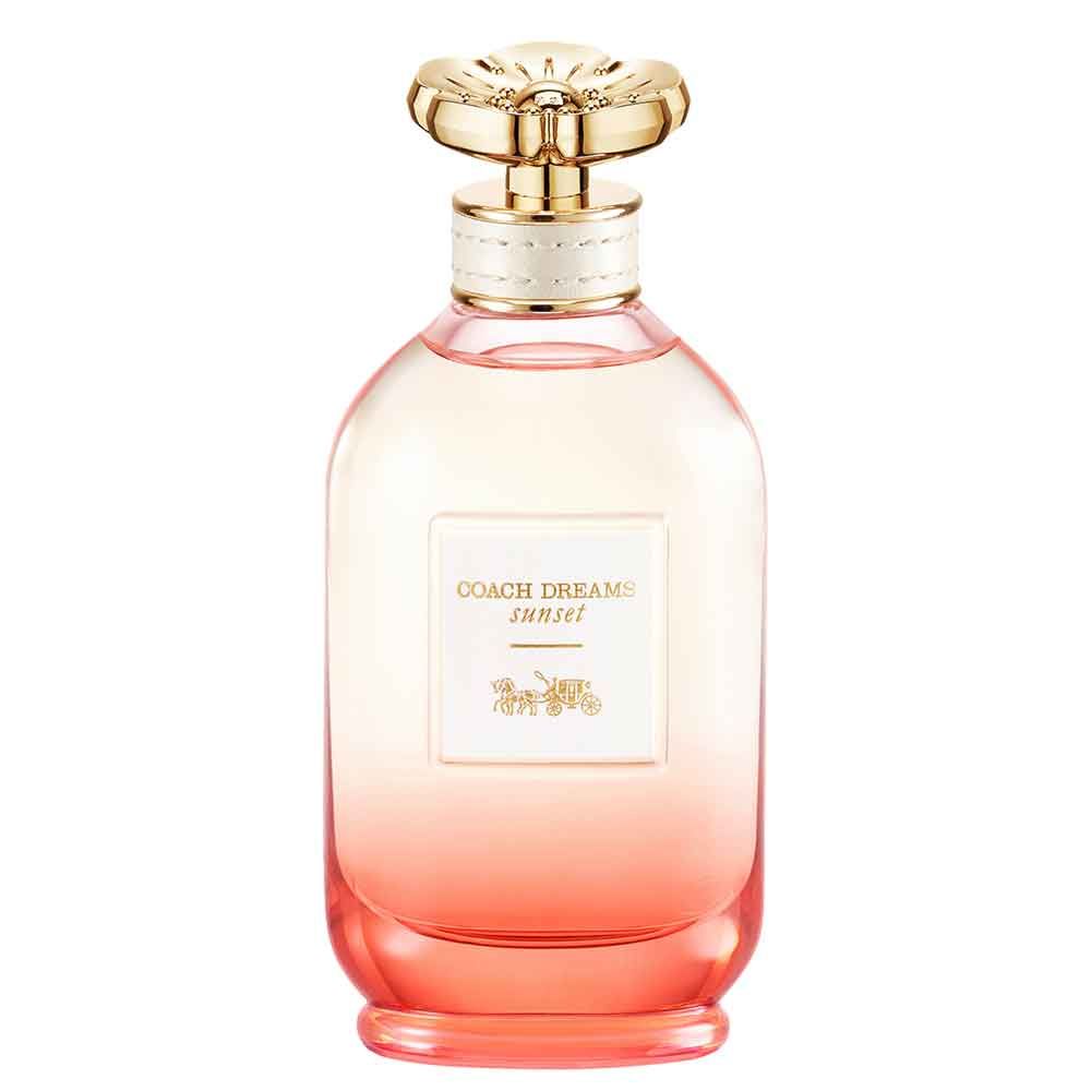 Flacon de parfum avec bouchon doré. Inscription: Coach Dreams Sunset. Dégradé de rose à orange.