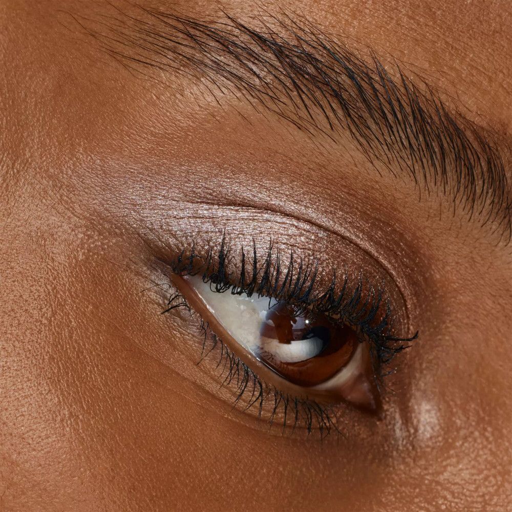 Gros plan sur un œil avec fard à paupières. Yeux bruns, fard à paupières brun doré.