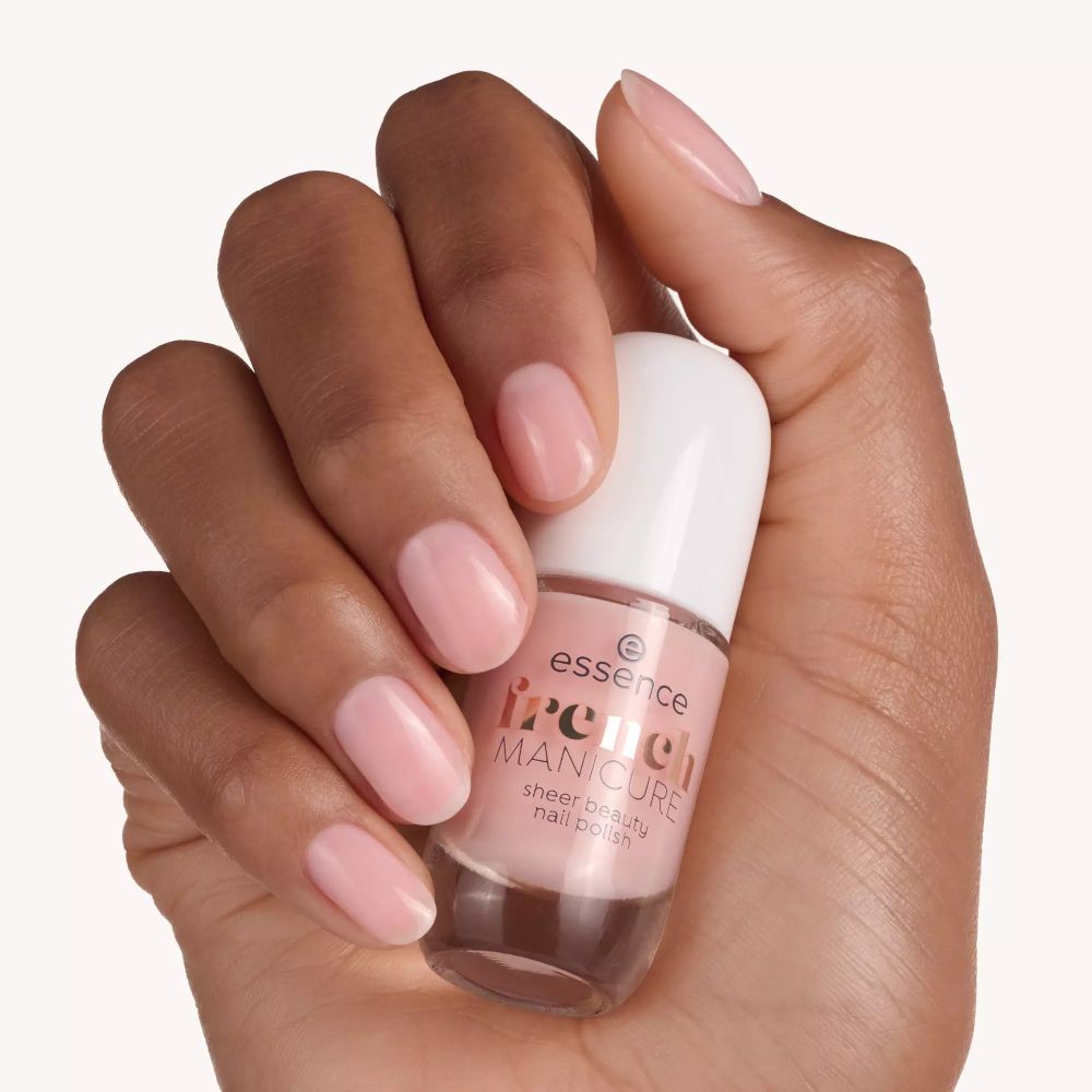 Main tenant un flacon de vernis à ongles. Inscription : essence french MANICURE sheer beauty nail polish. Ongles vernis.