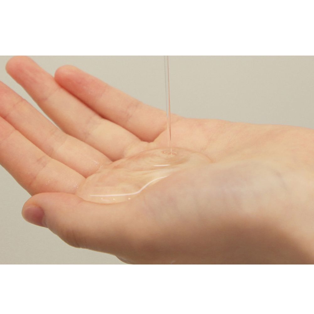 Hand met transparante gel. Gel stroomt in de handpalm. Achtergrond is licht.