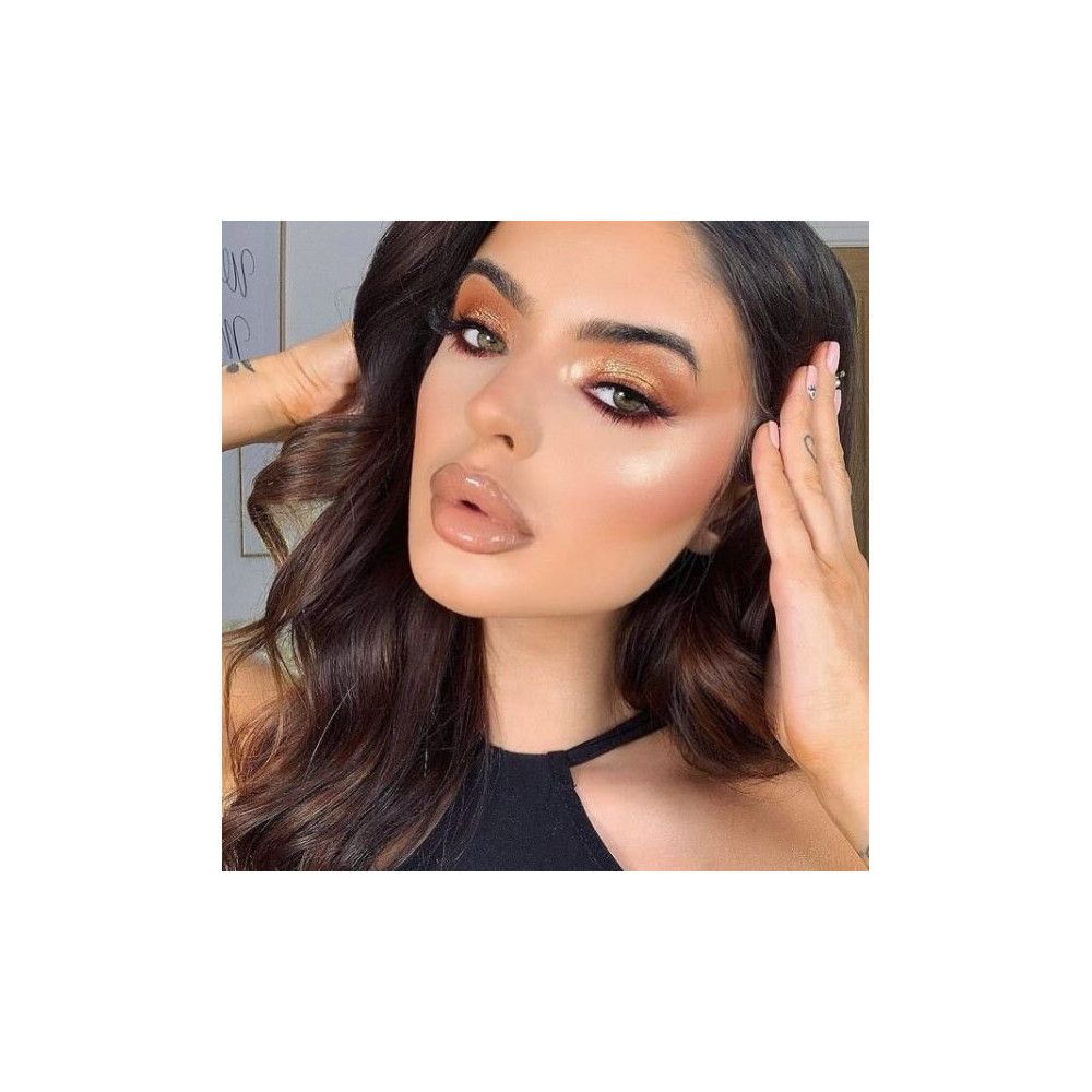 Portrait d'une femme maquillée. Accent sur les yeux avec faux cils. Cheveux brun foncé, haut noir.