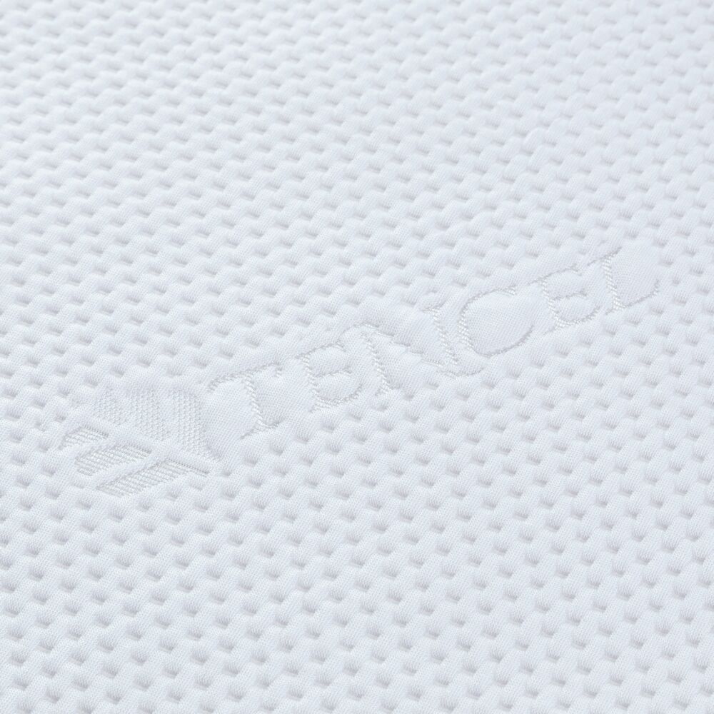 Close-up van het witte hoeslaken. Reliëf tekst TENCEL op het oppervlak.