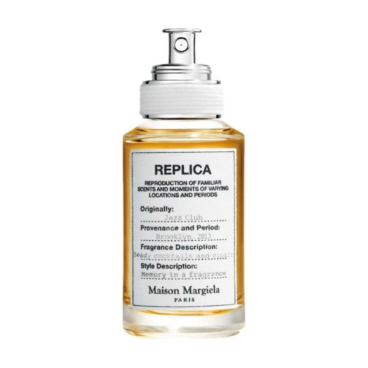 Flacon en verre avec vaporisateur argenté. Étiquette avec informations produit: REPLICA Jazz Club. Maison Margiela Paris.