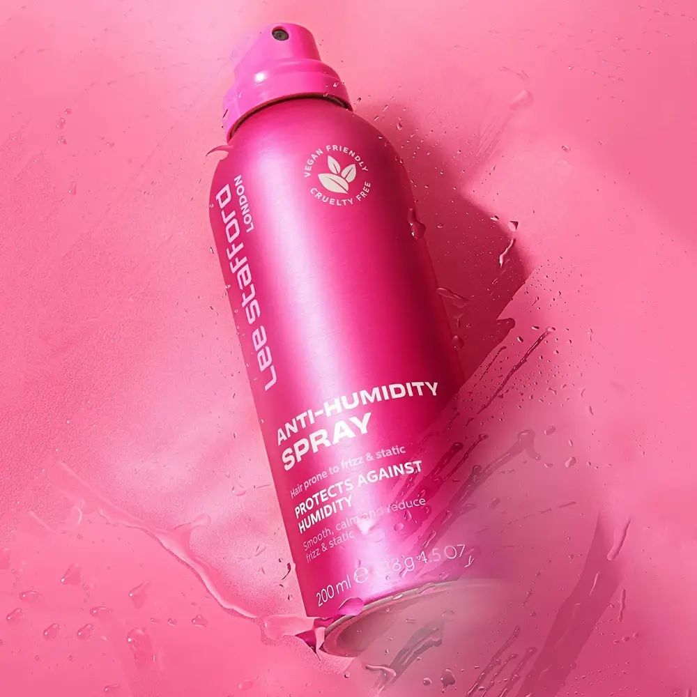 Roze spuitfles op roze achtergrond. Opschrift: Lee Stafford London, Anti-Humidity Spray, Vegan, Cruelty Free.