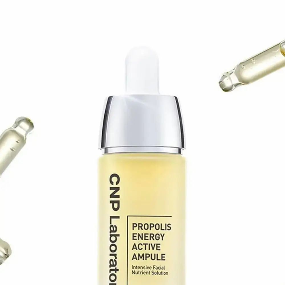CNP Laboratory Propolis Energy Ampoule. Gele vloeistof in glazen fles met zilveren dop en pipet. Pipetten op de achtergrond.