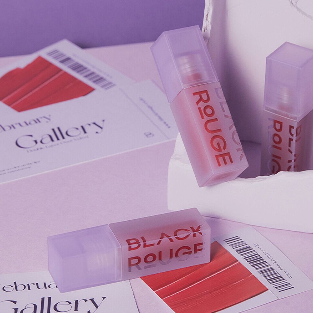 Plusieurs flacons de gloss avec des bouchons violets. Le nom BLACK ROUGE est visible.