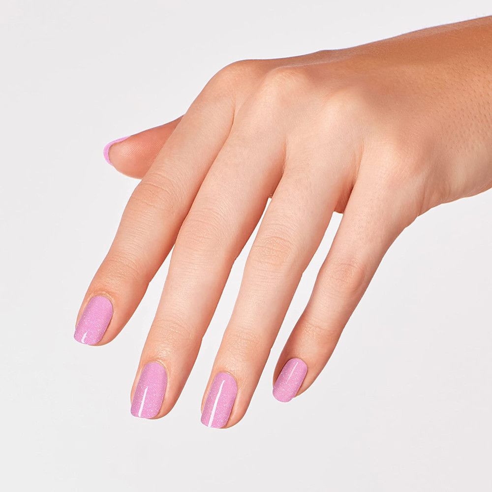 Hand met gelakte nagels. Roze nagellak met glitter.