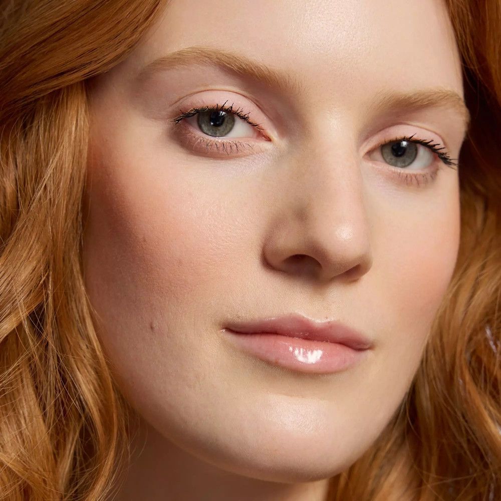 Close-up van een vrouw met getinte lippen. Rood haar.