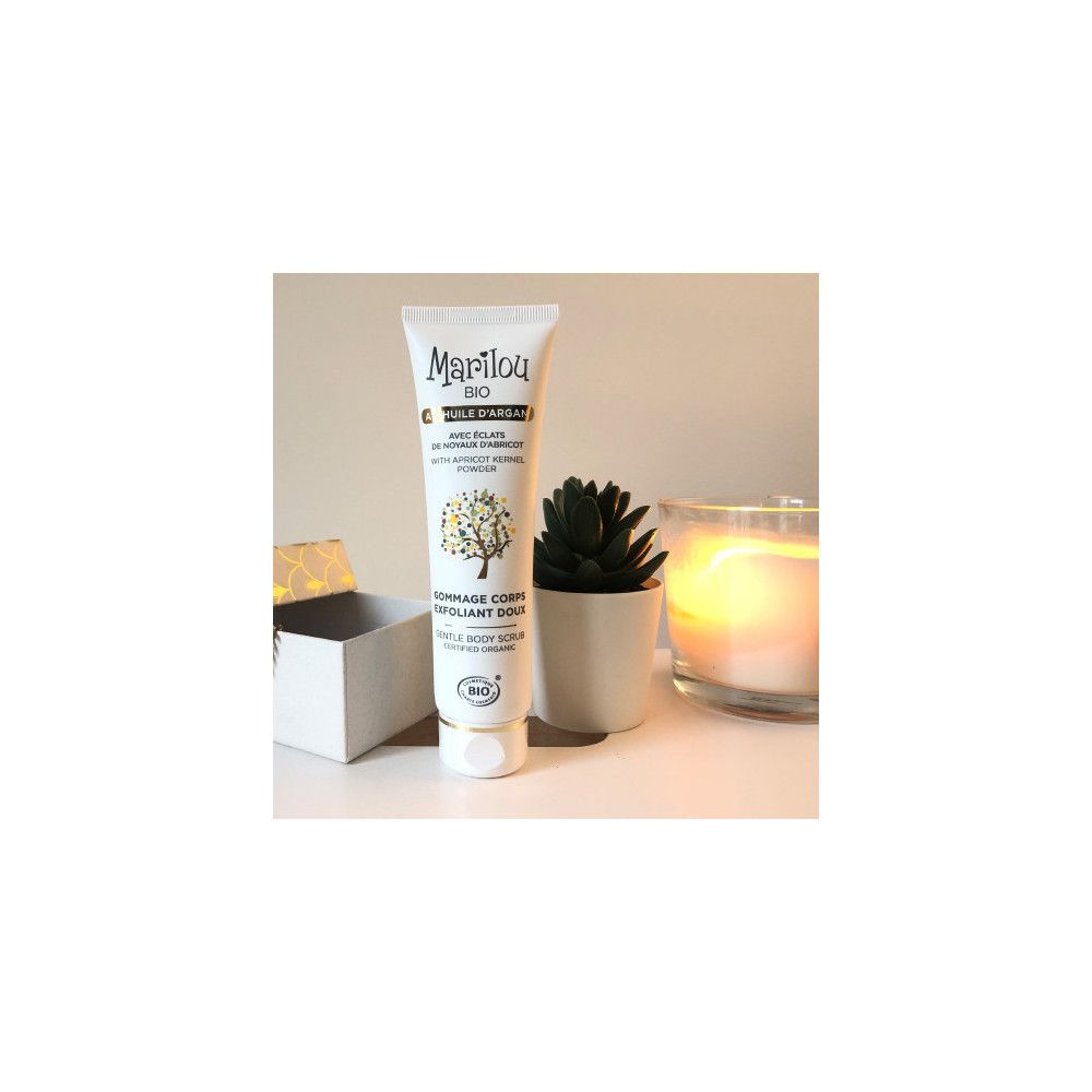 Tube blanc Marilou Bio à côté d'une bougie, plante et boîte. Ambiance claire.