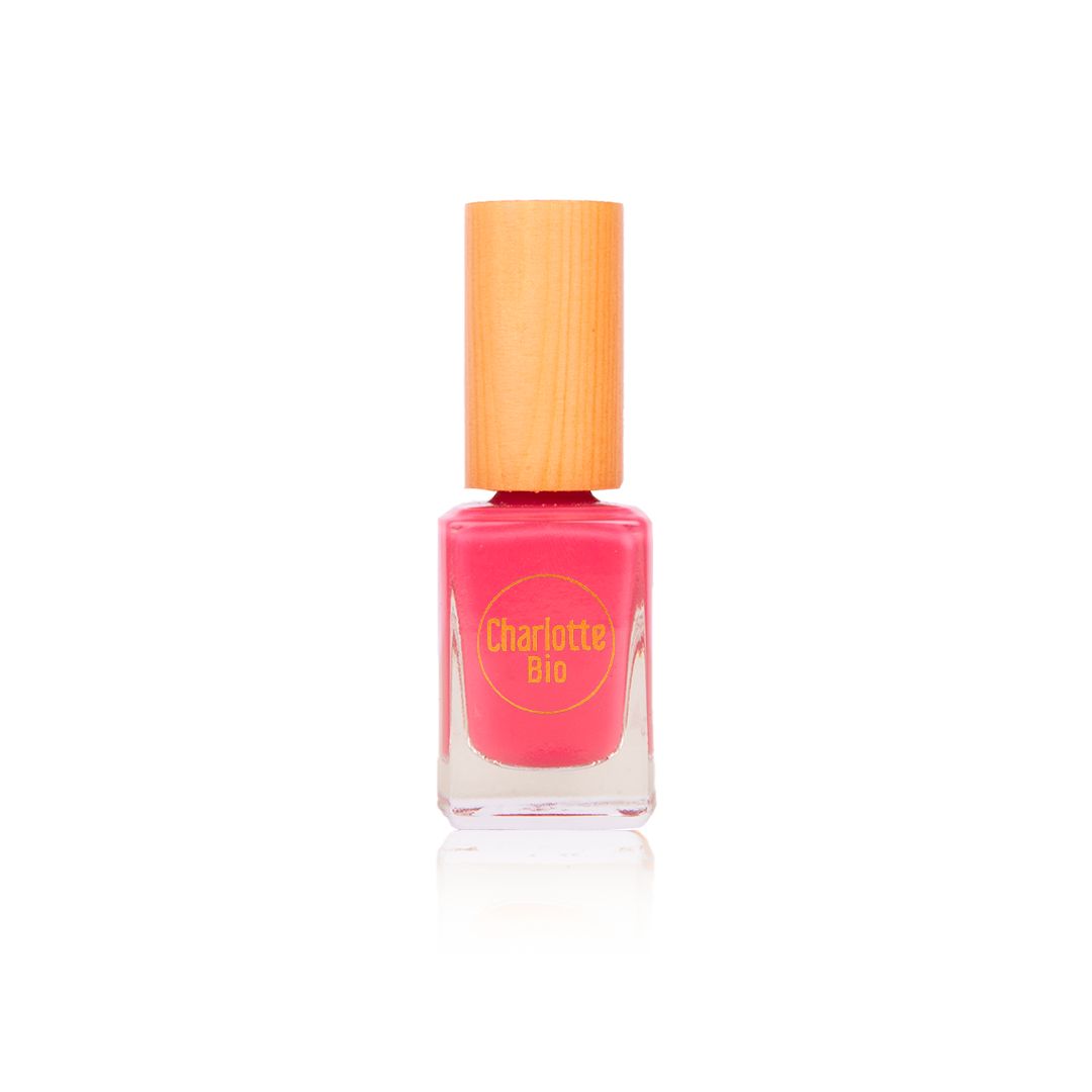 Flacon de vernis à ongles rose avec bouchon en bois. Le nom "Charlotte Bio" est visible.