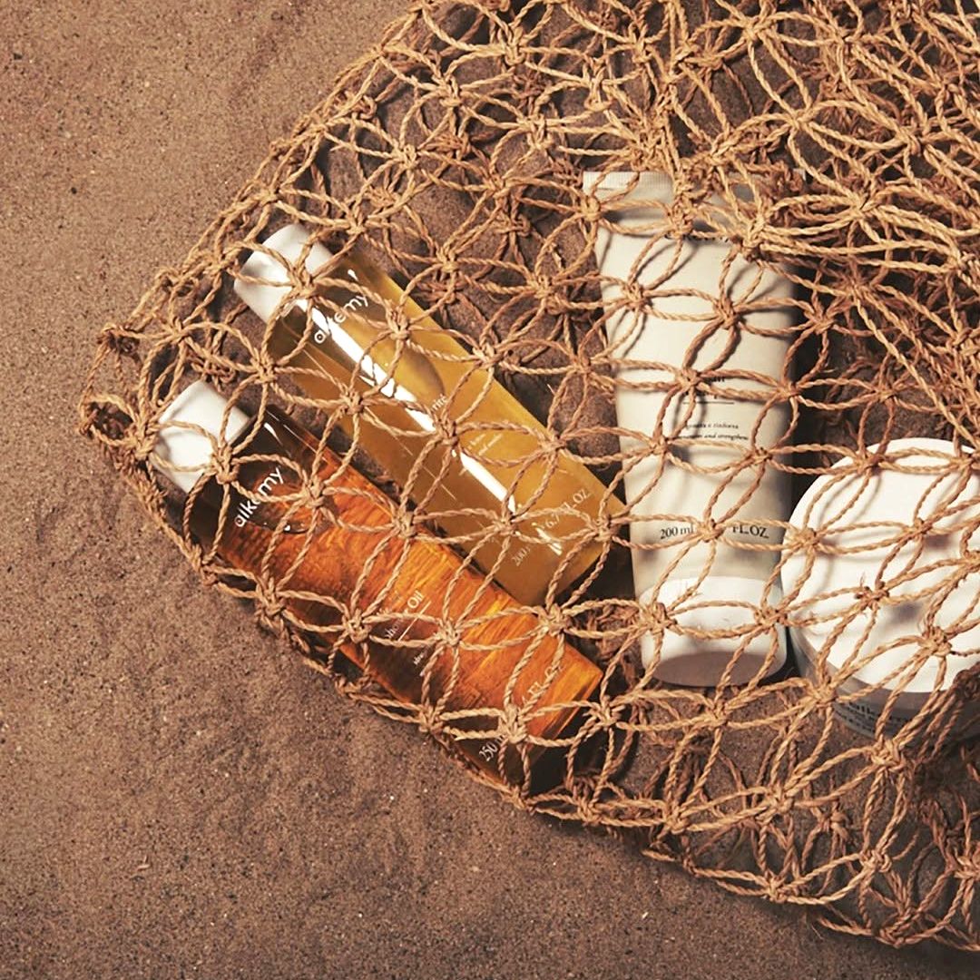 Un sac avec des produits Alkemy sur la plage.