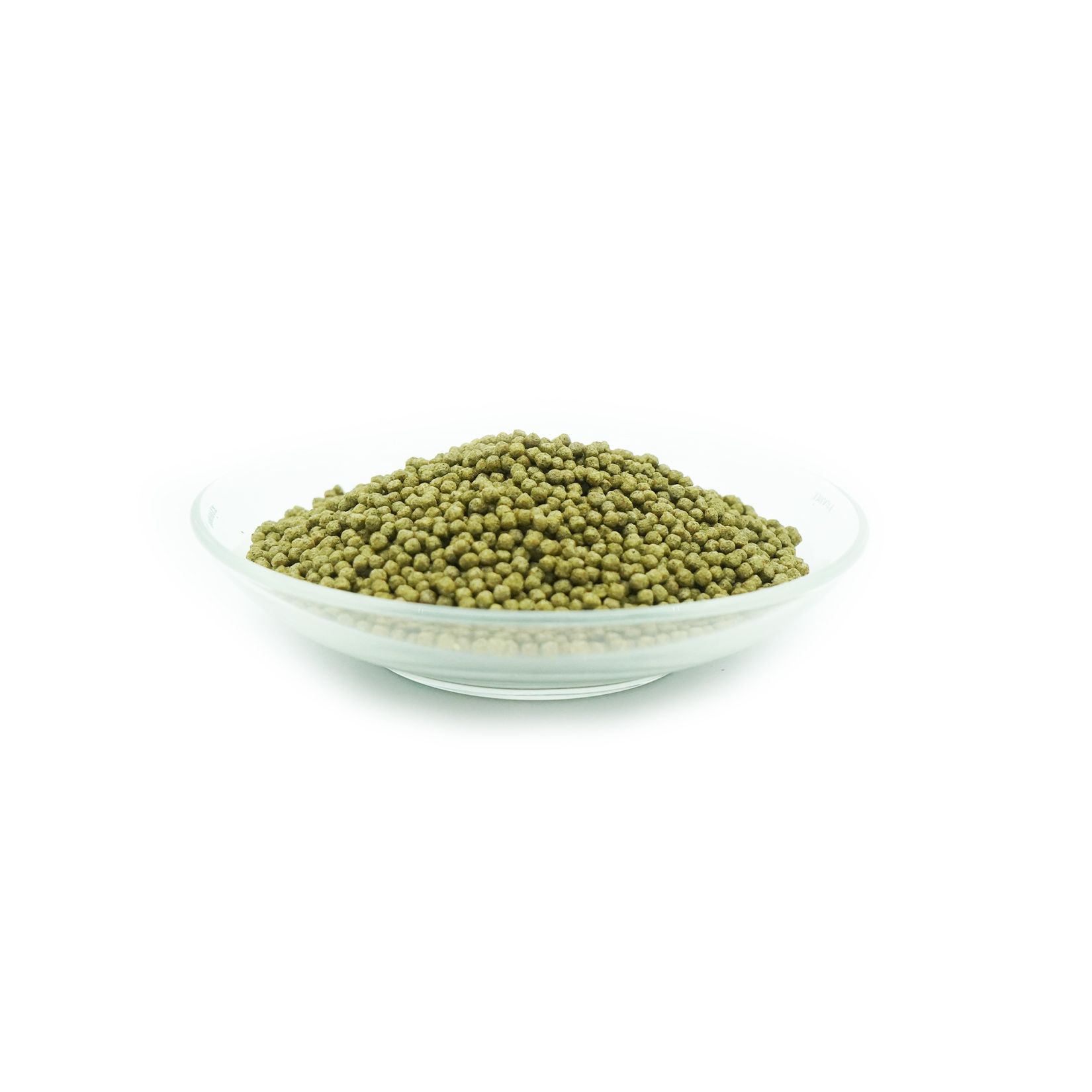 Groene koi-visvoer in een glazen kom. Ronde pellets, 3 mm diameter.
