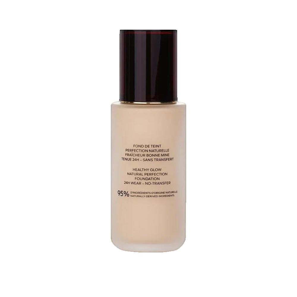 Flesje vloeibare foundation. Zwarte dop, gouden ring, beige vloeistof. Tekst: 'Fond de Teint', 'Healthy Glow', '24H Wear'.