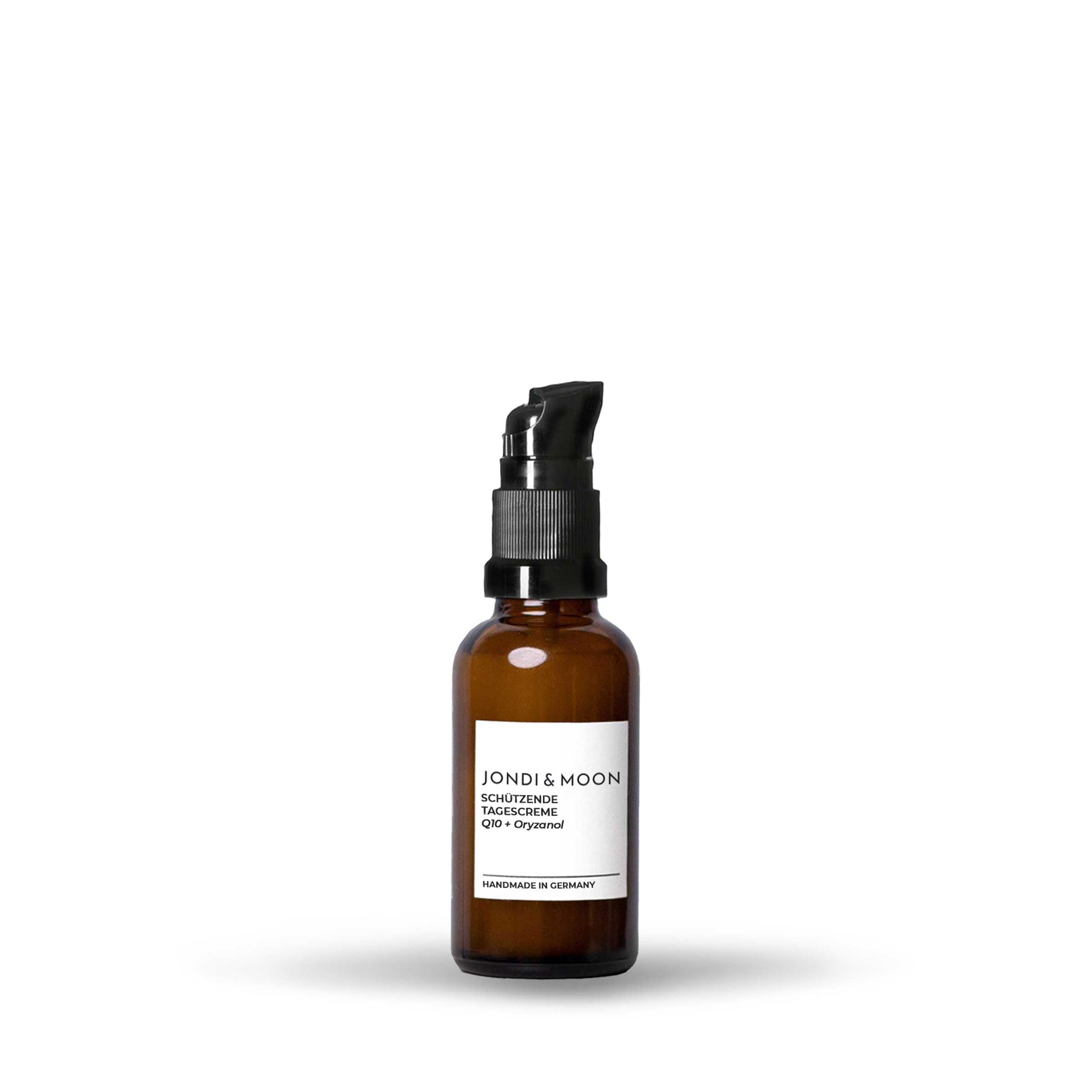 Bruine glazen fles met zwarte pomp. Etiket met productinformatie. Opschrift: JONDI & MOON, Schützende Tagescreme, Q10 + Oryzanol. Handmade in Germany.