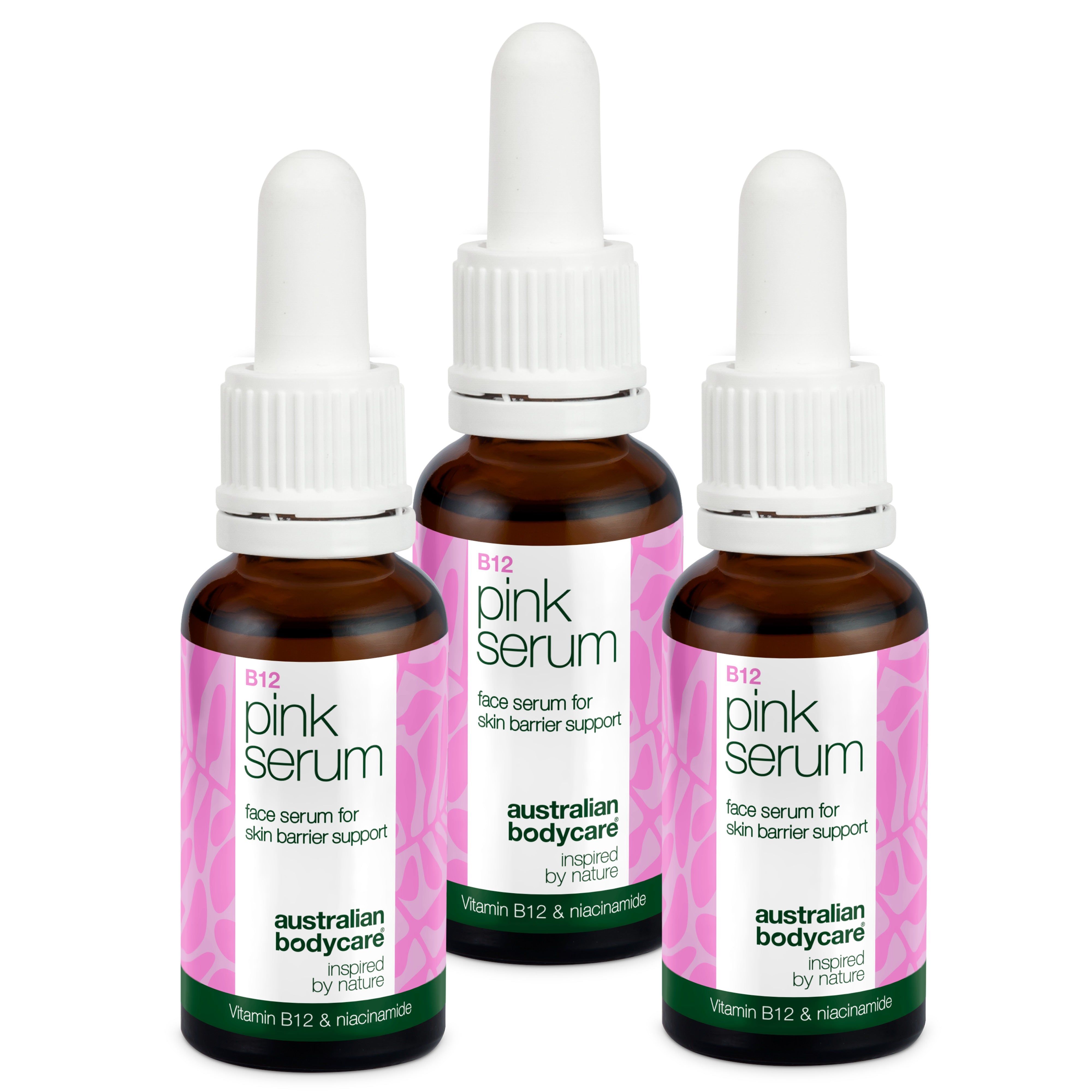 Trois flacons de sérum avec compte-gouttes. Flacons en verre brun, bouchon blanc, étiquette rose. Inscription : B12 pink serum.